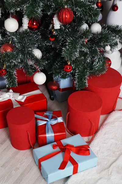 Viele schön verpackte Weihnachtsgeschenke in runden Schachteln in roter Farbe — Stockfoto