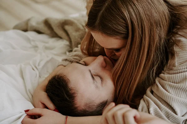 Close-up retrato de um belo jovem casal beijando na cama em casa — Fotografia de Stock