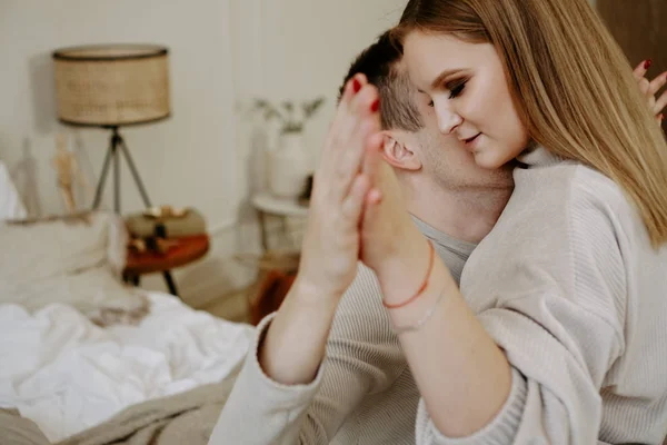 Casal de mãos dadas na cama, os amantes se abraçam relaxando no quarto — Fotografia de Stock