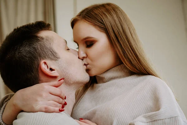 Close-up portrait of a beautiful young kissing couple in bed at home — Stock Photo, Image