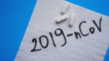 Coronavirus in China. New coronavirus 2019-nCoV. Napkin and pills on blue