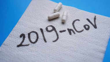 Coronavirus in China. New coronavirus 2019-nCoV. Napkin and pills on blue