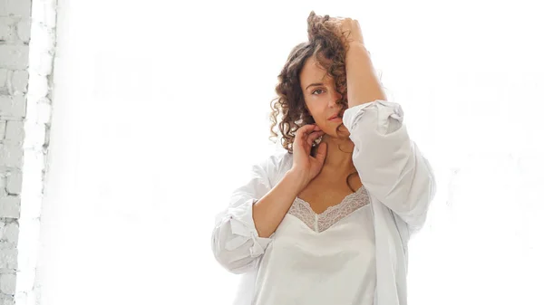 Sexy young woman in white shirt in bedroom - white light from window — Stok fotoğraf