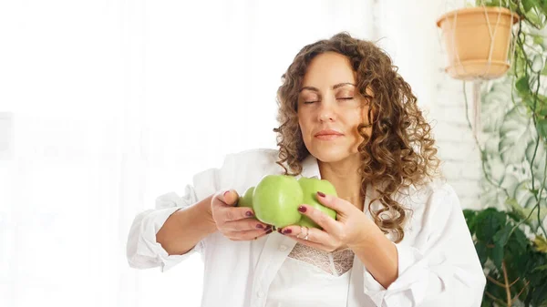 Красивая молодая женщина, нюхающая яблоко — стоковое фото