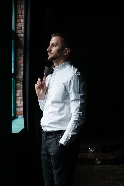 Vista em perfil de um jovem empresário parado perto da janela — Fotografia de Stock