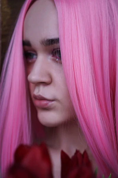Retrato de uma menina sonhadora com cabelo rosa brilhante com flores perto do rosto — Fotografia de Stock