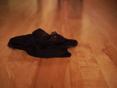 Siyah ayakkabılı kadın dantelli iç çamaşırını yerden aldı ve gitti.