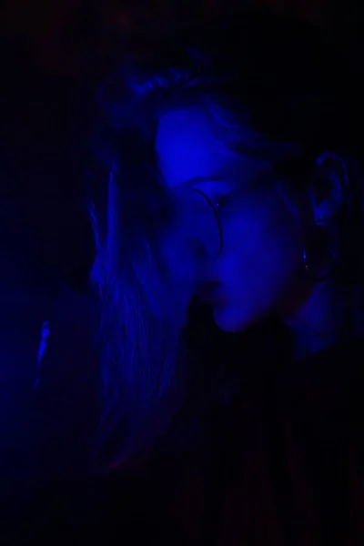 Close up portrait of vaping girl in neon blue light — Stock Photo, Image