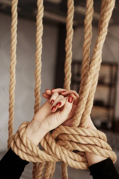 Tied with a rope female hands with red nails. Concept of sex or violence — Stock Photo, Image