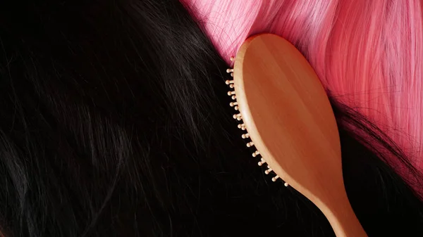 Pinkfarbene und schwarze Perücke mit langen Haaren und Kamm — Stockfoto