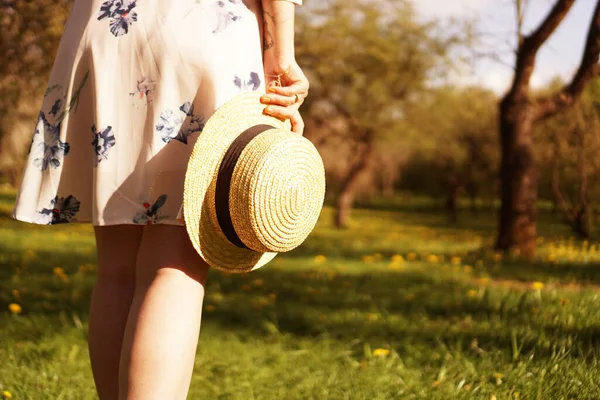 Foto primo piano - ragazza con un cappello di paglia che tiene un cappello tra le mani — Foto Stock