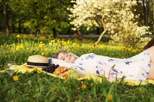 Mladá dívka ležící na kostkovaném plotě. Piknik. Přírodní světlo — Stock fotografie