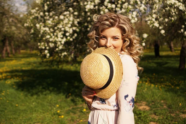 Kobieta pokryta połową twarzy słomkowym kapeluszem - szczęśliwy czas w zielonym ogrodzie — Zdjęcie stockowe