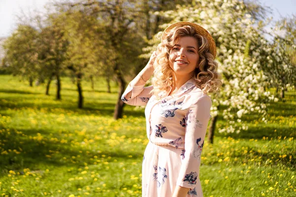 Lächelnde Sommerfrau mit Strohhut im Park — Stockfoto