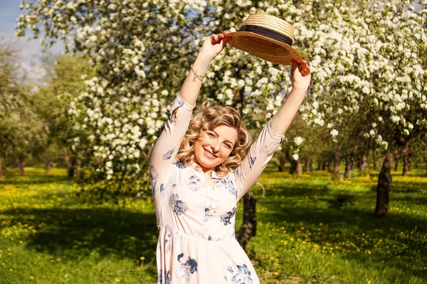 Usmívající se letní žena se slamákem v parku — Stock fotografie