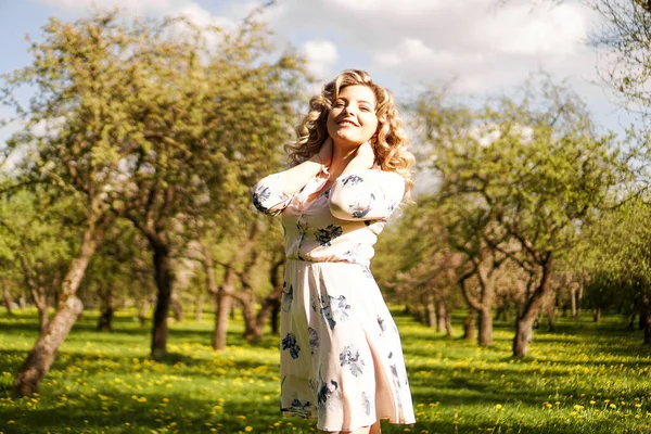 Schöne junge Frau im Apfelgarten an einem sonnigen Frühlingstag — Stockfoto