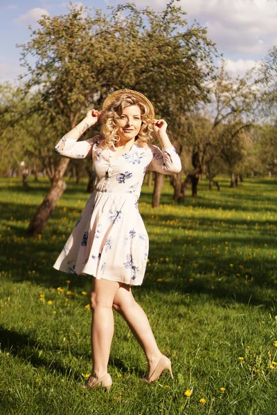 Lächelnde Sommerfrau mit Strohhut im Park — Stockfoto