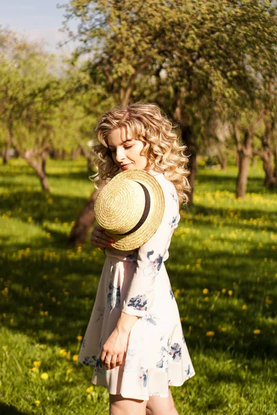 Schöne junge Frau im Apfelgarten an einem sonnigen Frühlingstag — Stockfoto