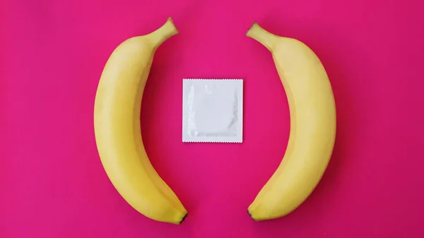 Preservativos e duas bananas juntos, conceito de contraceptivos e prevenção — Fotografia de Stock