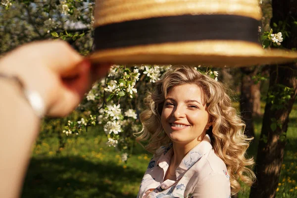 Uśmiechnięta letnia kobieta w słomkowym kapeluszu w parku — Zdjęcie stockowe