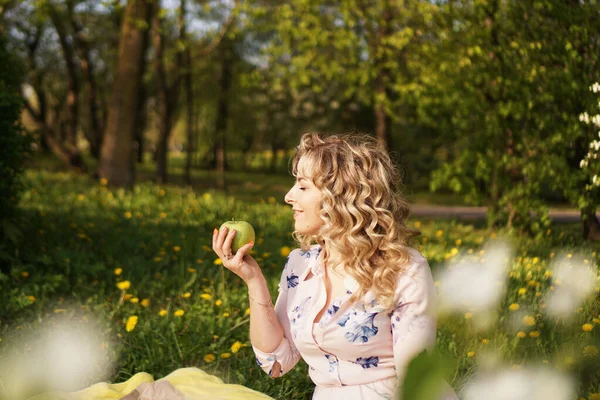 Donna con mela a un picnic nel giardino estivo — Foto Stock