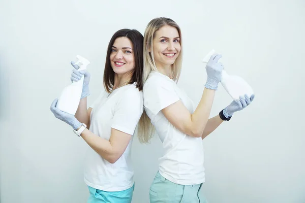 Dos mujeres sostienen la botella de aerosol - antiséptico o detergente como armas. Concepto de salud — Foto de Stock