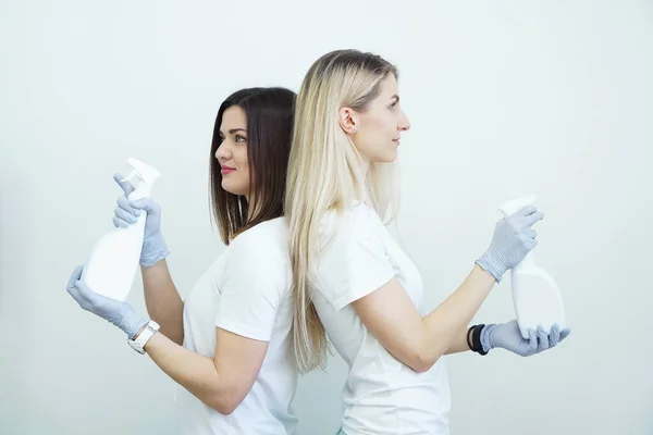 Dos mujeres sostienen la botella de aerosol - antiséptico o detergente como armas. Concepto de salud — Foto de Stock