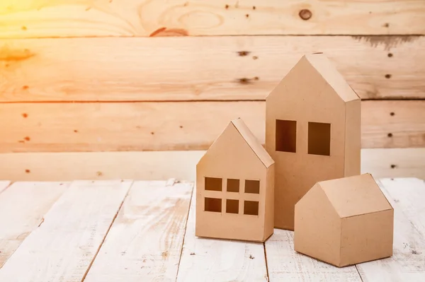 Modelo de casa de papelão no chão de madeira e fundo — Fotografia de Stock