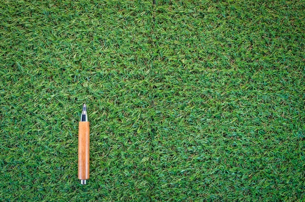 sharp pencil on green grass  texture background