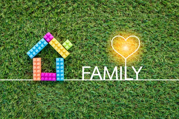 Familienkonzept mit Hausspielzeug auf grünem Gras.jpg — Stockfoto