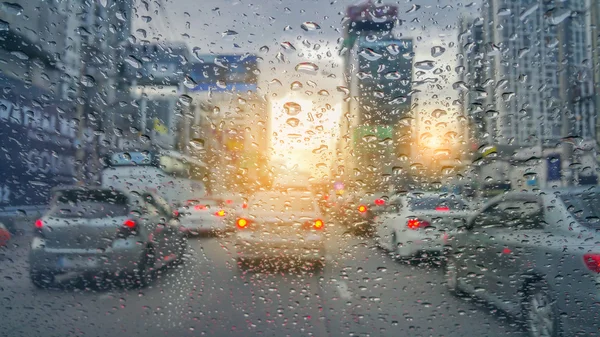 Tráfego desfocado visto através de um pára-brisas de carro coberto — Fotografia de Stock