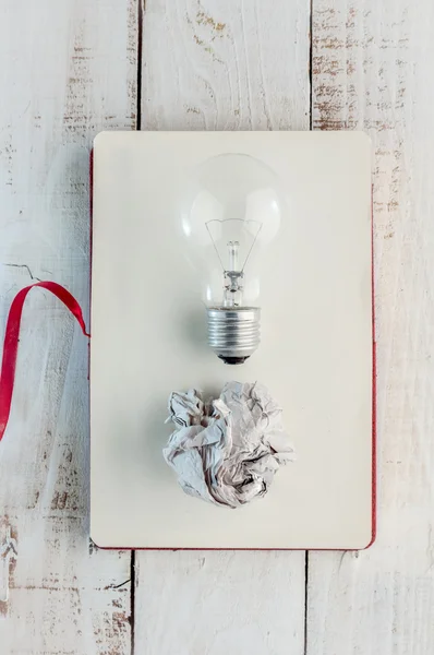 light bulb with trash paper on blang notebook page