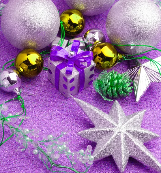 Weihnachtsschachtel Geschenk mit silberner Kugel herum mit lila Hintergrund — Stockfoto
