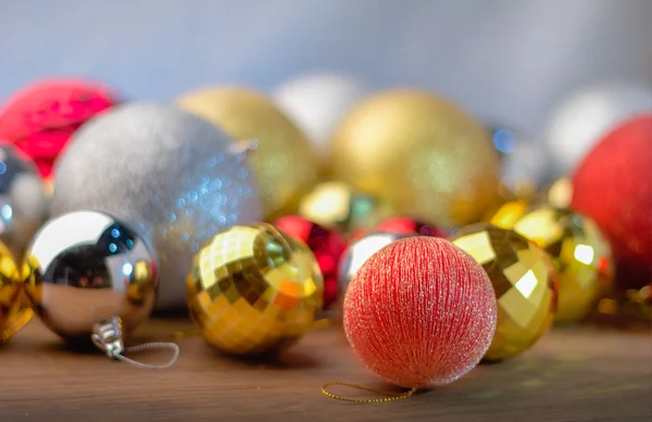 Palle di Natale d'oro e rosso e argento sul tavolo di legno — Foto Stock