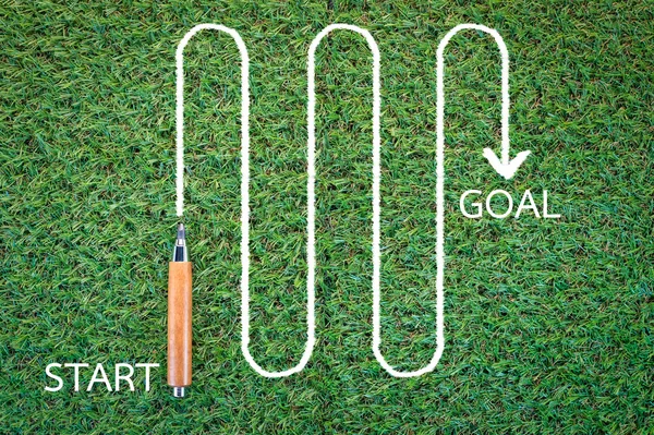 Рисование старта к цели в зеленой траве — стоковое фото