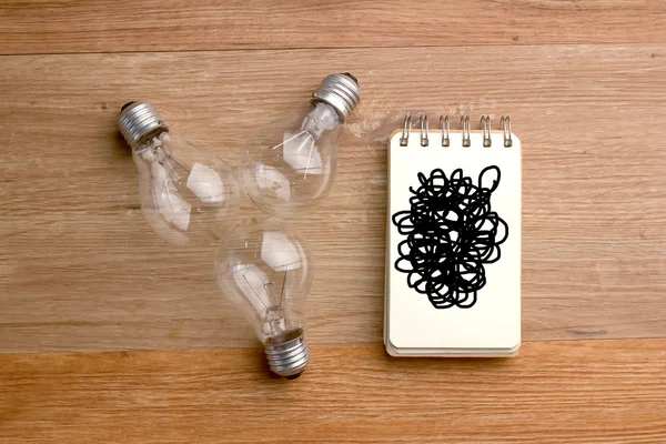 Notebook with many light bulbs — Stock Photo, Image