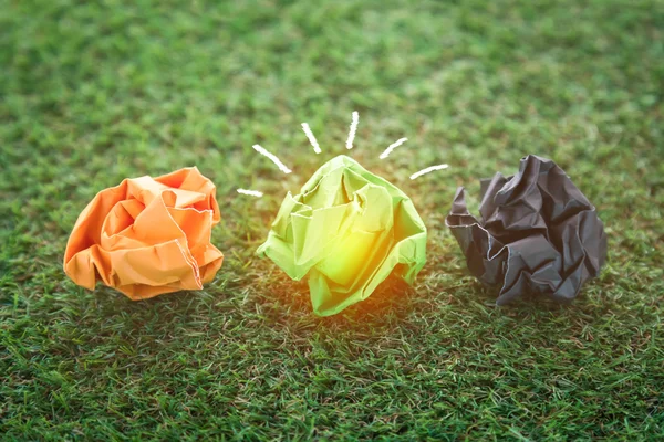 Три разноцветных бумажных мусорных шара на зеленой траве — стоковое фото