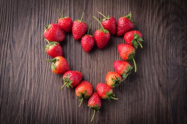 Eski ahşap arka planda taze çilekler.