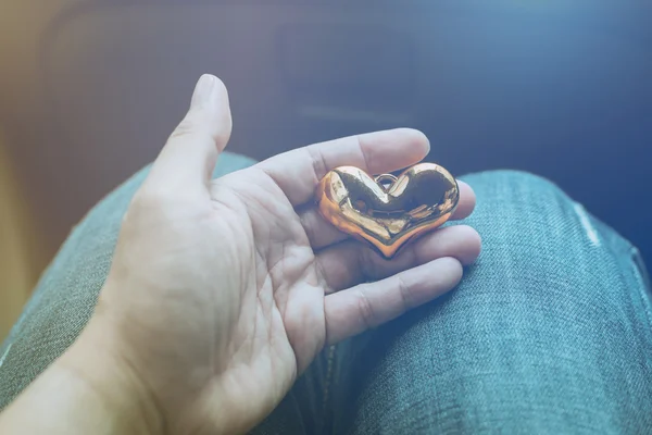 male hands hold gold heart shape love concept