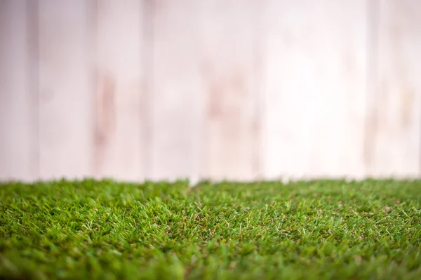 Verde pavimento in erba e sfondo in legno bianco — Foto Stock