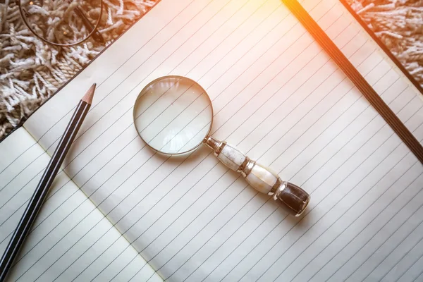 Blank page notebook with a magnifying — Stock Photo, Image