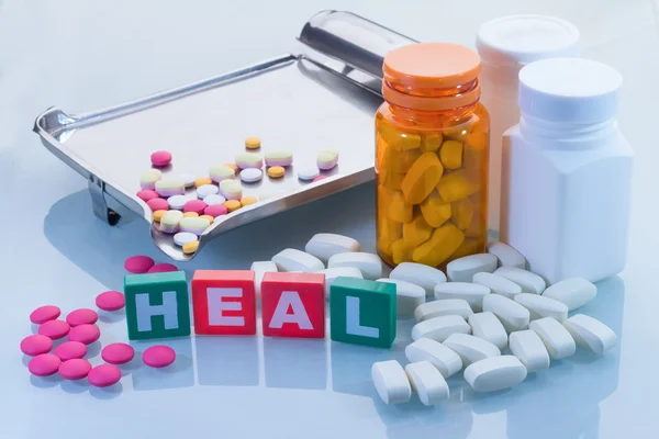 Medische concept met genezen tekst en pillen met flessen achtergrond — Stockfoto