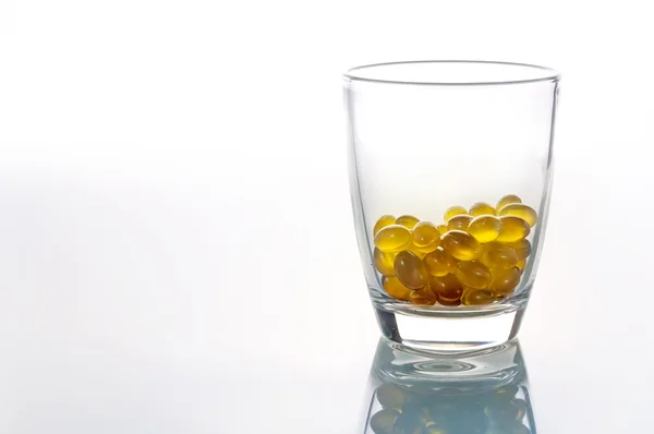 Oil capsules in glass on white background  with copy space..jpg — Φωτογραφία Αρχείου