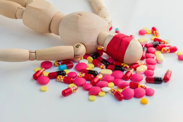 Blind wooden figure with pills on white floor — Φωτογραφία Αρχείου