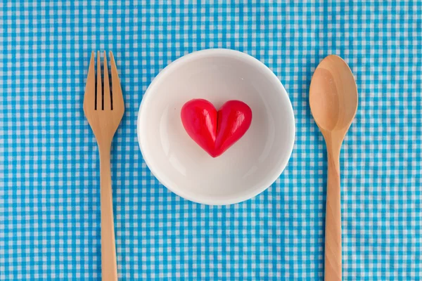 Rood hart onwhite kom keramiek met houten vork en lepel — Stockfoto