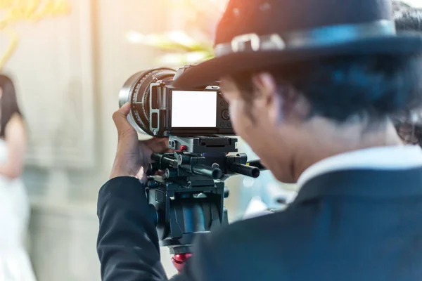 Videographer takes video camera with blank screen — Stock Photo, Image