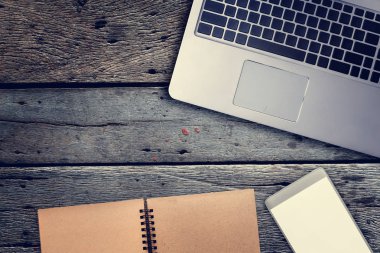 Not Defteri, dizüstü bilgisayar ve f ile ahşap masa boş ekran smartphone