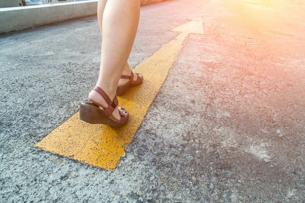 Желтый указатель улицы с походкой женщины в кожаной обуви — стоковое фото