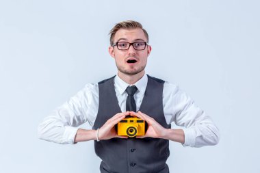 Genç adam, beyaz gömlek ve kravat, gülümseyen yüz ve Studio, beyaz arka plan üzerinde tutarak kamera ile bel oynuyor