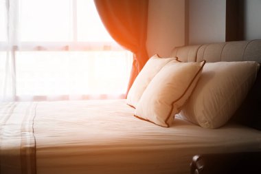 Yatak hizmetçi-up temiz beyaz yastık ve yatak örtüsü yatak sabah ile. Yakın çekim. Objektif yetenek güneş ışığı altında.